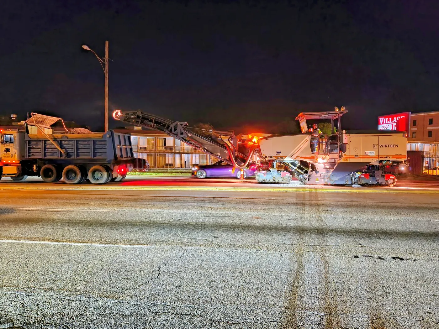 Dump truck and road milling machine operating at night